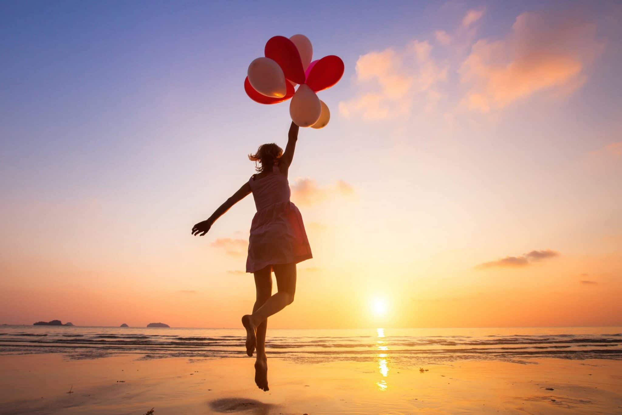 imagination, happy girl jumping with multicolored balloons at sunset on the beach, fly, follow your dream