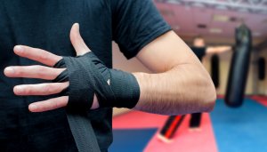 Man putting bandages on hands before marshall arts training in s