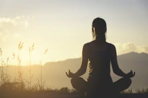 silhouette fitness girl practicing yoga on mountain