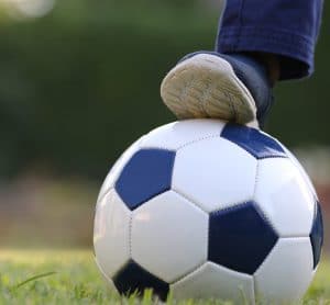 Engagement partie foot avec ballon bleu et blanc sur terrain de gazon