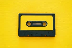 Retro cassette tape over yellow wooden table. top view.