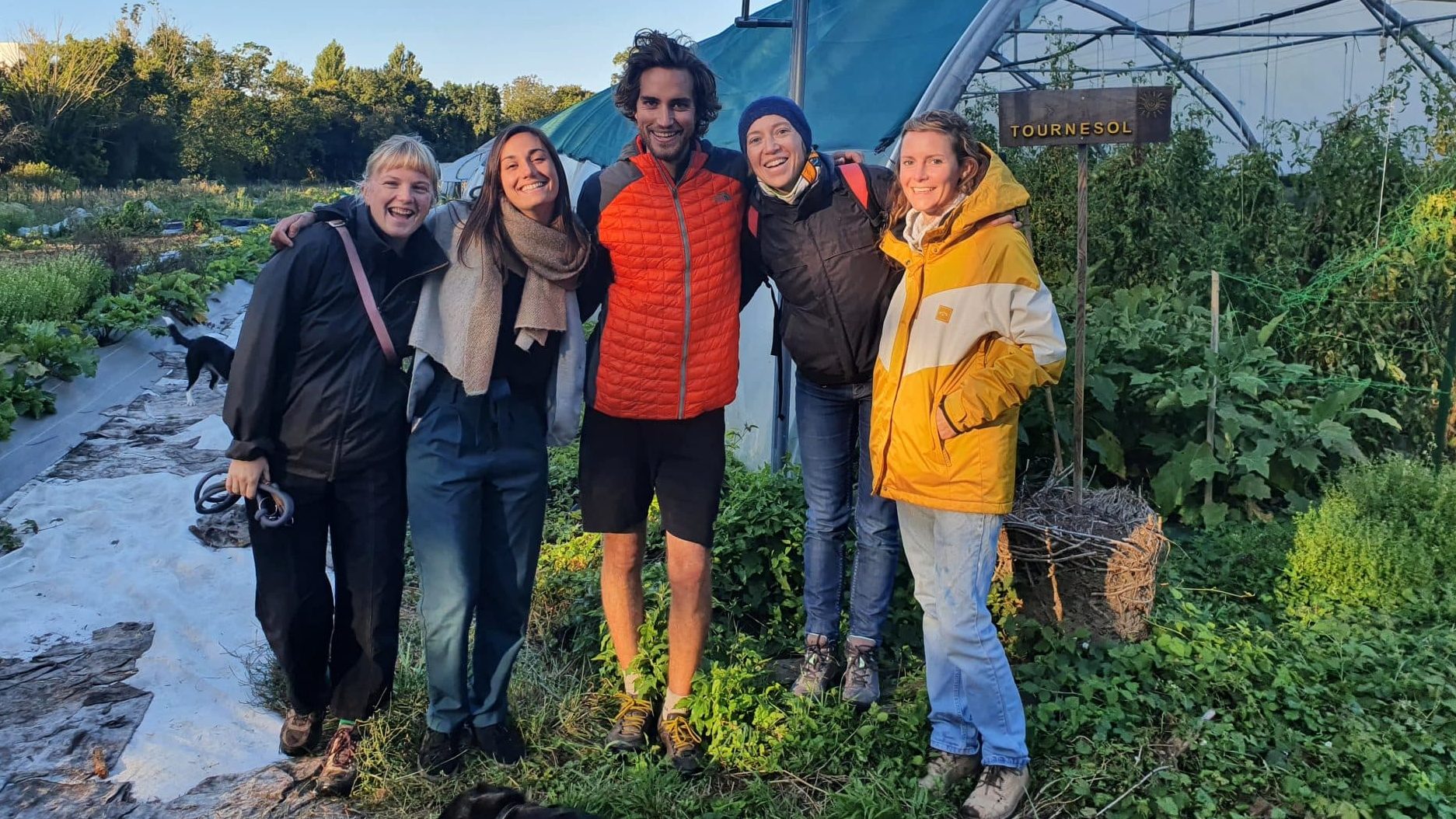 Robin et Florine de la Super Ferme pose devant une serre entourés de trois bénévoles