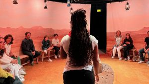 "24h de la vie d’une femme" : une femme debout fait face à à un public assi en cercle