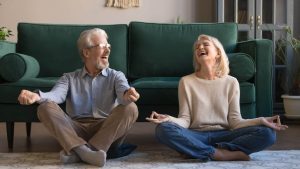 Un homme et une femme sourient en faisant du yoga