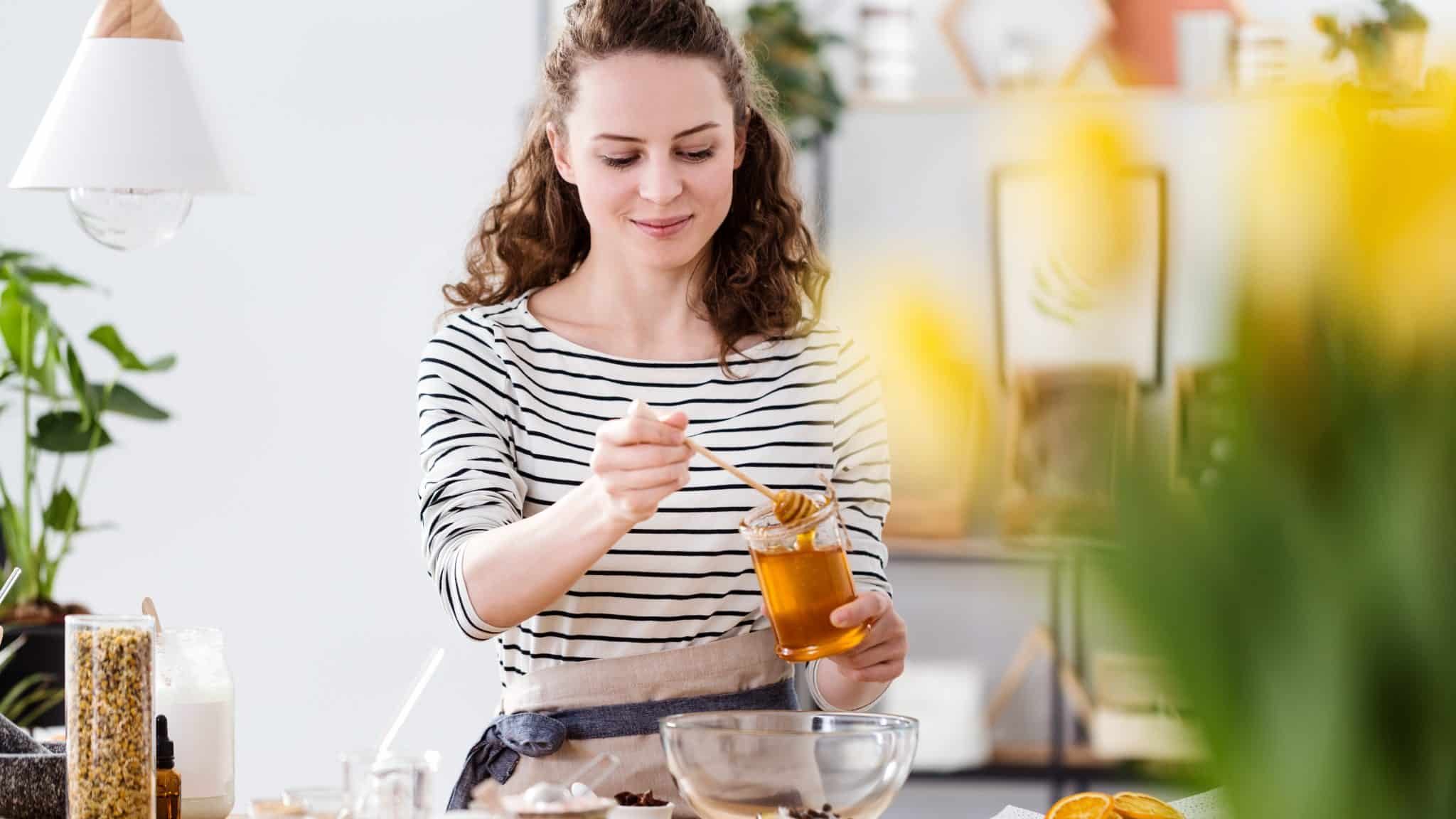 Une femme cuisine avec du miel.