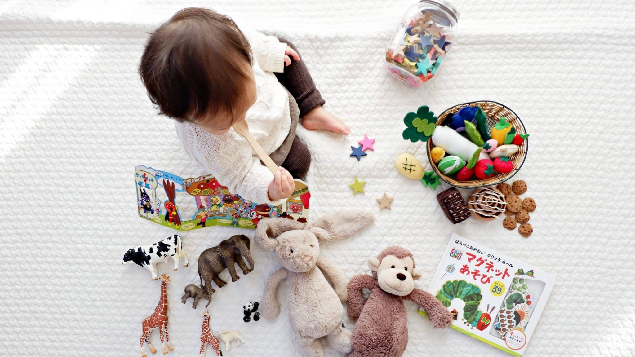 Un jeune enfant entouré de jouet en tout genre.