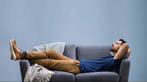 La sédentarité : un homme allongé sur canapé