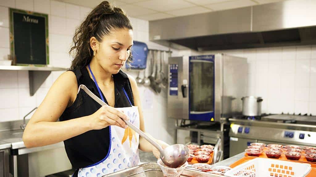 femme qui sert un plat en cuisine