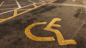 Disabled parking. Accessible parking spot. Blue badge. Yellow wheelchair sign on the ground