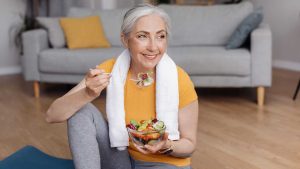 Une yogini qui mange un bol de fruits.