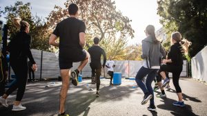 Des adultes et des enfants font du sport dans un parc