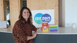 Marion du B' pose dans les studios d'AirZen Radio à côté de ses 7 romans