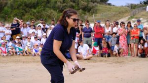 Florence Dell'Amico s'apprête à relâcher dans l'océan une tortue marine. Elle est entourée de 500 personnes