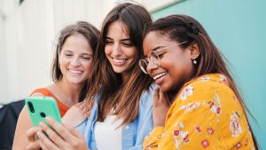 Trois adolescentes avec un téléphone.