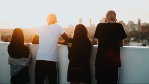 Quatre jeunes sont adossés à un muret ils regardent l'horizon