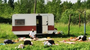 Un cours de hatha yoga en plein air devant la Yogaravane.