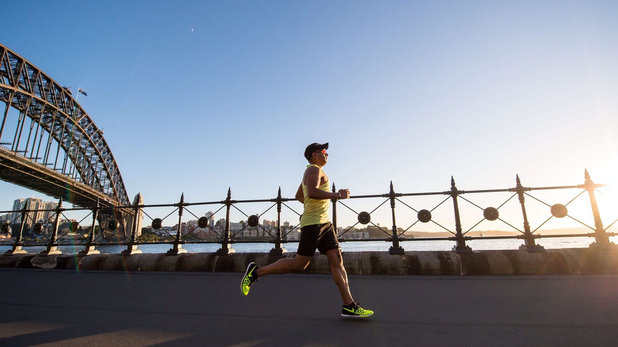 man in yellow tank top running near shore