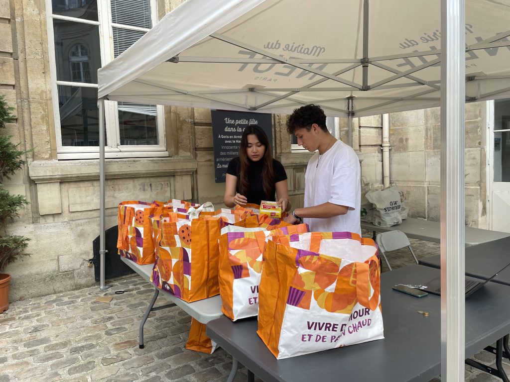 Deux bénévoles distribuent des paniers alimentaires