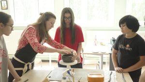 Des élèves suivent un cours de poterie avec une enseignante