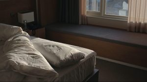 white bed linen near brown window curtain