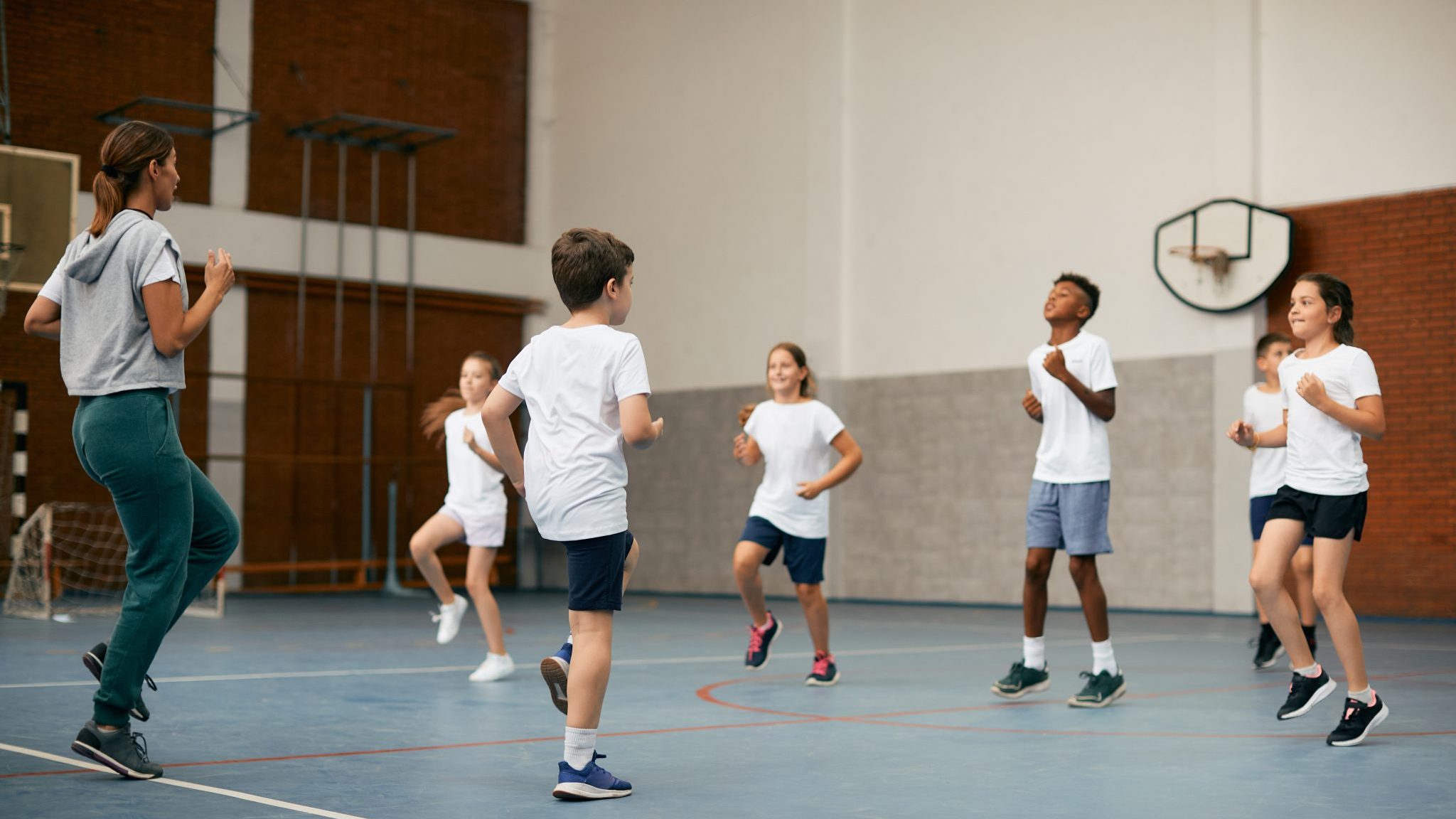 Des enfants font du sport avec leur entraineur.