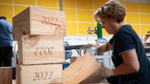 Une femme travaille le bois pour en faire une caisse de vin