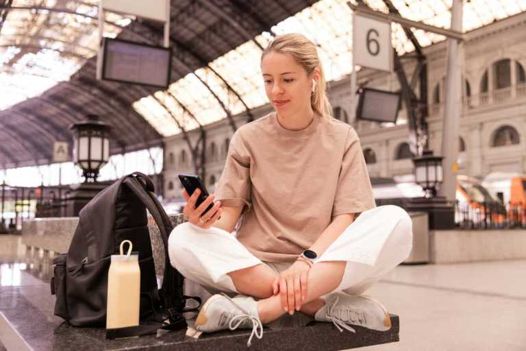 Ado et son téléphone dans une gare