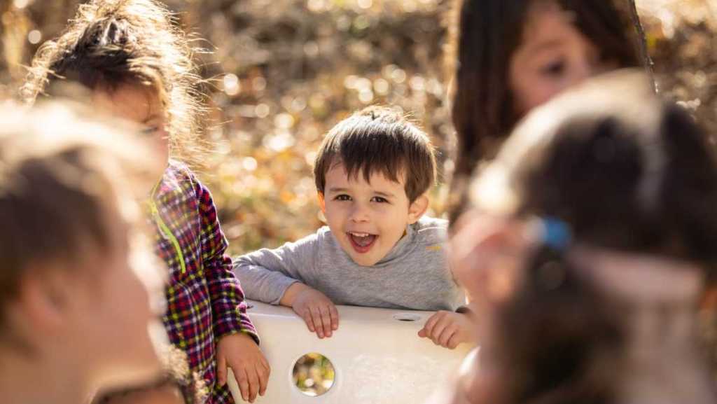 enfant heureux dehors autour d'une table