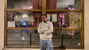 Homme debout devant bar le Motel dans Paris