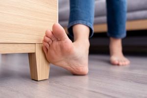 Pieds qui se cognent dans un meuble - source : Dall-E