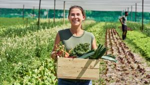 Une femme qui vient de récolter des légumes.