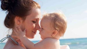 Moment tendresse entre une mère et son bébé à la plage