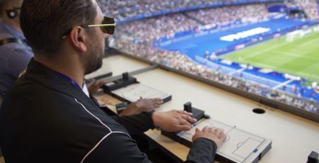 Homme aveugle qui suit un match de football avec la tablette tactile, au Stade de France