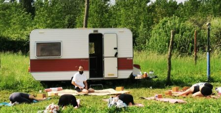 Un cours de hatha yoga en plein air devant la Yogaravane.