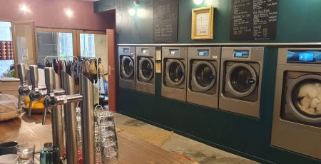 Il y a un bar et en face se trouvent plusieurs machines à laver