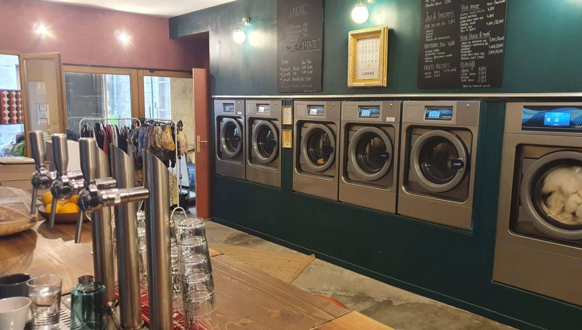 Il y a un bar et en face se trouvent plusieurs machines à laver