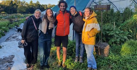 Robin et Florine de la Super Ferme pose devant une serre entourés de trois bénévoles