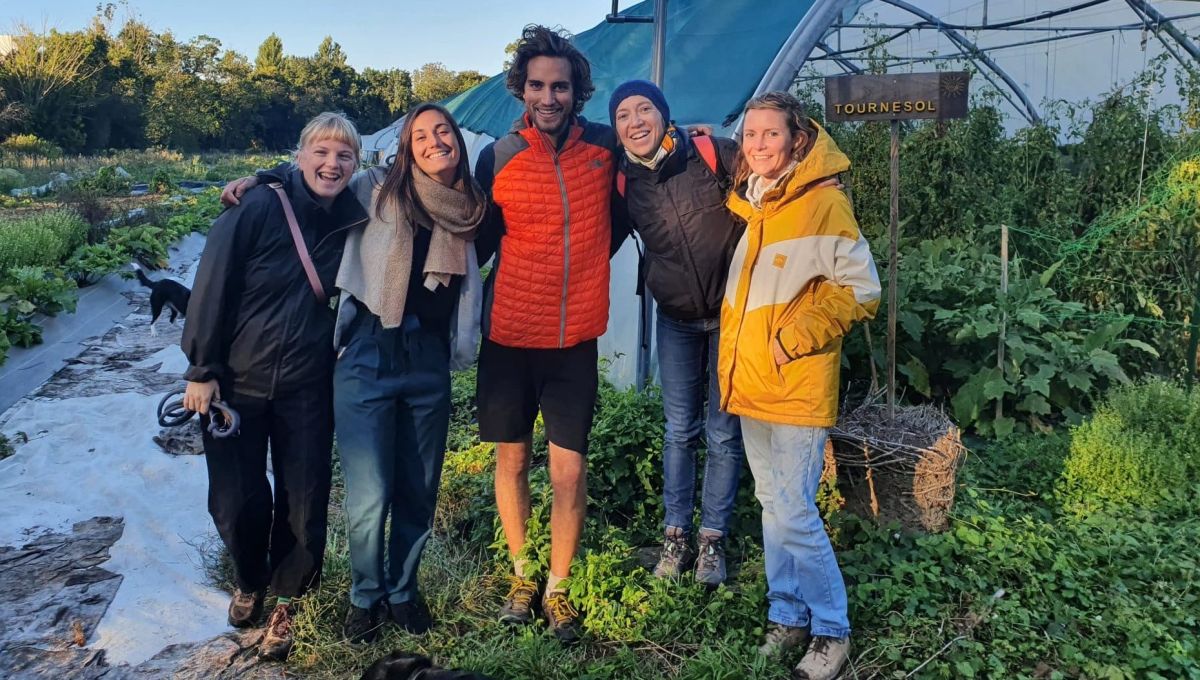 Robin et Florine de la Super Ferme pose devant une serre entourés de trois bénévoles