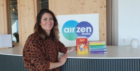 Marion du B' pose dans les studios d'AirZen Radio à côté de ses 7 romans