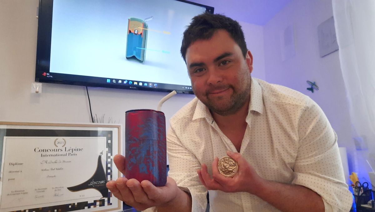 William Talabot pose avec son invention Dreasynk, et avec la médaille de bronze qu'il a reçu