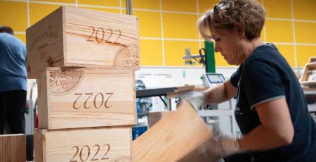 Une femme travaille le bois pour en faire une caisse de vin