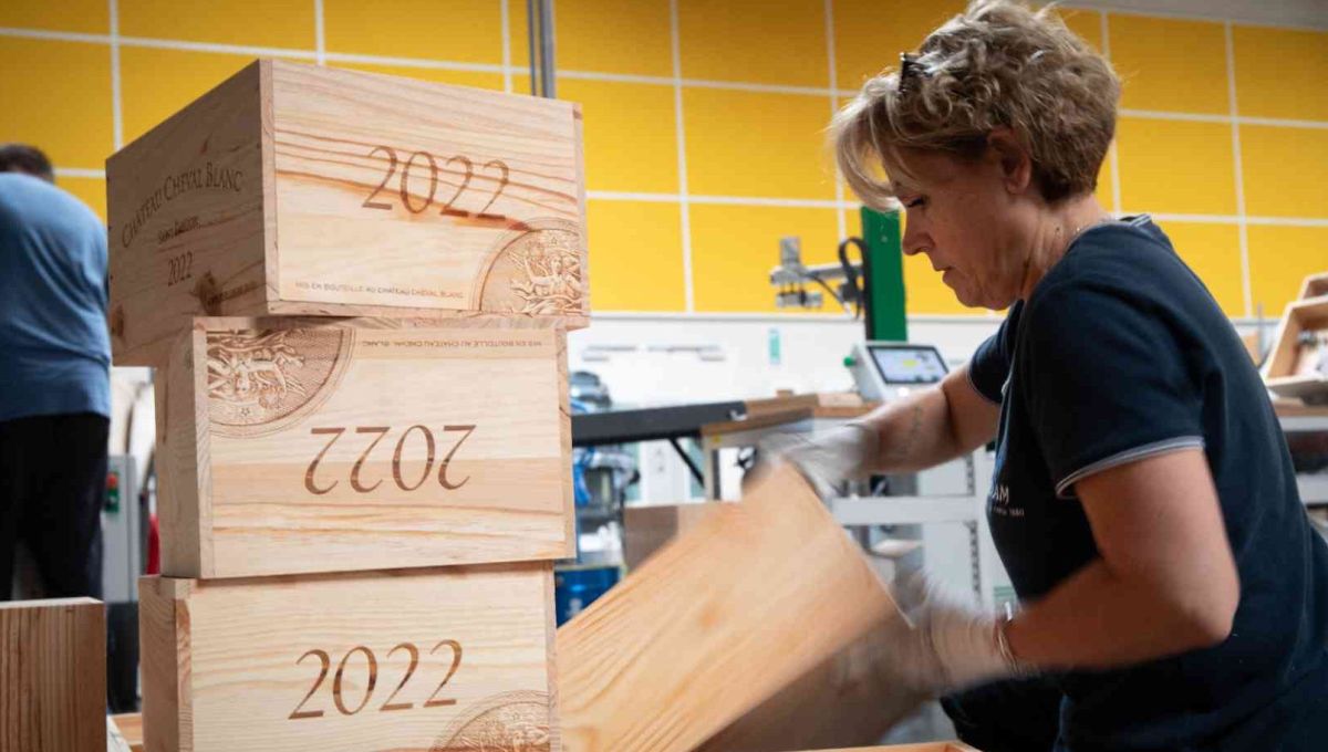 Une femme travaille le bois pour en faire une caisse de vin