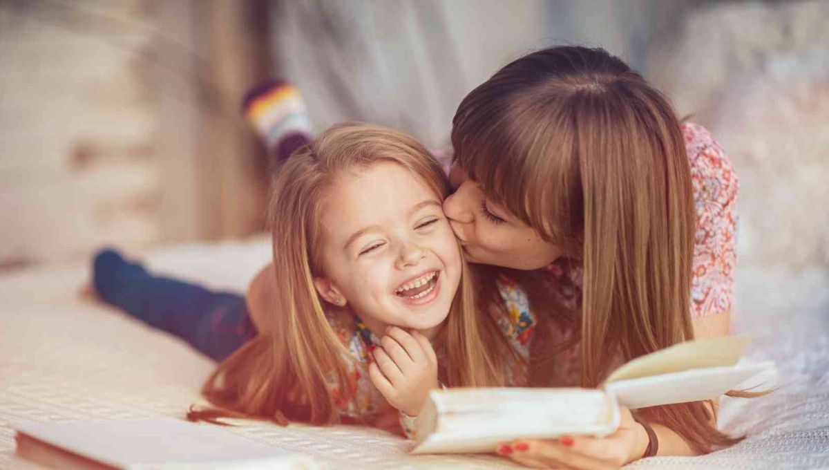 Maman qui câline sa fille en lui lisant un livre.