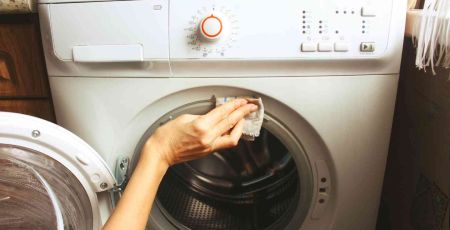 une personne nettoie sa machine à laver