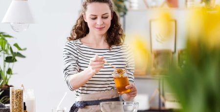 Une femme cuisine avec du miel.