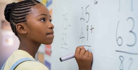 Jeune fille faisant des mathématiques au tableau