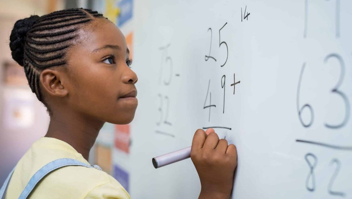 Jeune fille faisant des mathématiques au tableau