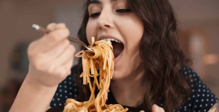 Femme qui mange des pâtes