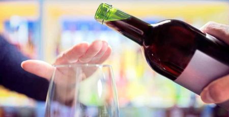 une main refuse qu'on remplir un verre de vin