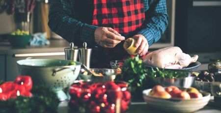 Un homme dans une cuisine avec un pot de moutarde.